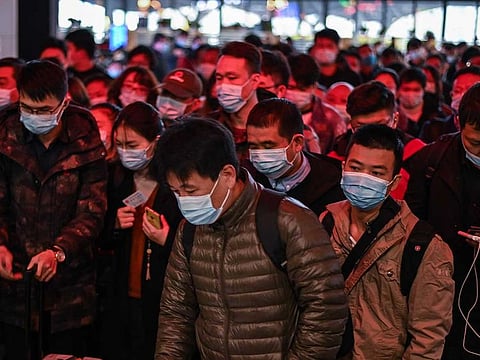 Passengers wearing face masks as a preventive measure against the COVID-19 coronavirus walk to their train at Wuhan railway station in Wuhan, China's central Hubei province on November 25, 2020.