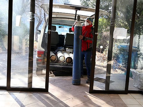 Miralem Sabic carries oxygen bottles from his private van to an improvised COVID-19 hospital in Konjic, Bosnia and Herzegovina.