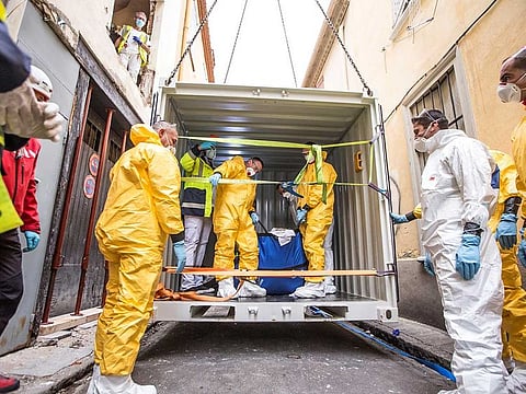 A container is lifted over a building by a crane before being used by doctors of the SAMU (French Urgent Medical Aid Service) to evacuate a man suffering from morbid obesity from the first floor of his home in Perpignan, southwestern France, on December 1, 2020.
