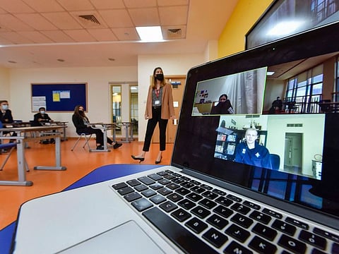 A grade 11 teacher teaches both in-class students and distance learners through live streamed lessons at GEMS World Academy Dubai