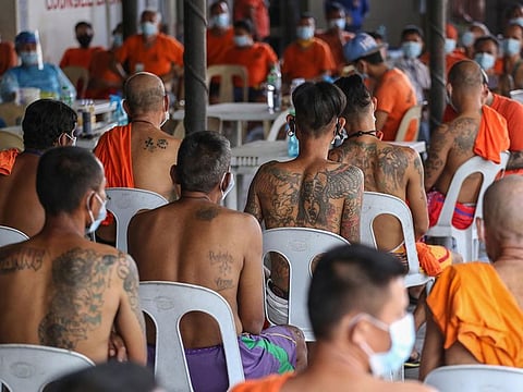 Inmates at the new Bilibid prison wait for their turn to have their tattoo removed in Manila.