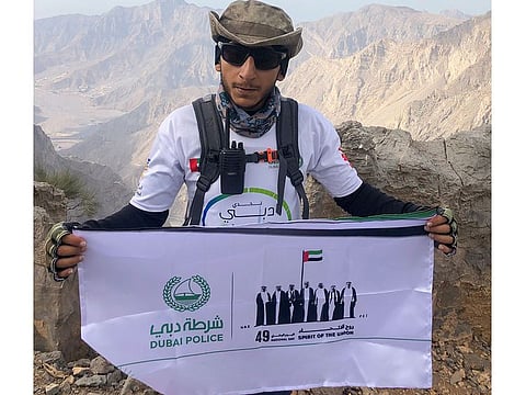 Ahmad Zein Al Yafei unfurls the Spirit of the Union banner on top of Jebel Jais.