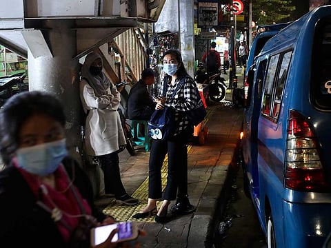 People wearing masks as a precaution against coronavirus outbreak, wait for public transport in Jakarta, Indonesia, Thursday, Dec. 3, 2020.