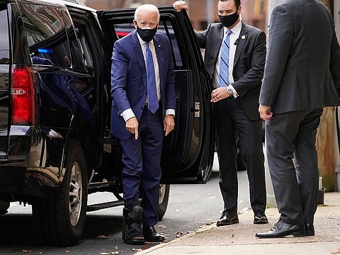 President-elect Joe Biden points to his medical boot as he arrives at The Queen theatre, Tuesday, Dec. 1, 2020, in Wilmington, Del.