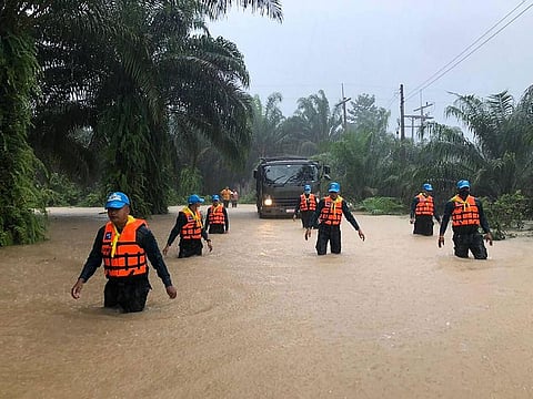 Security forces wading through flood waters in Surat Thani province in southern Thailand, following days of heavy rains.
