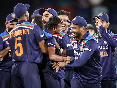 India's captain Virat Kohli (C) celebrates with teammate T Natarajan after he dismissed Australia's Glenn Maxwell during the 1st T20 match at Manuka Oval in Canberra on December 4, 2020.