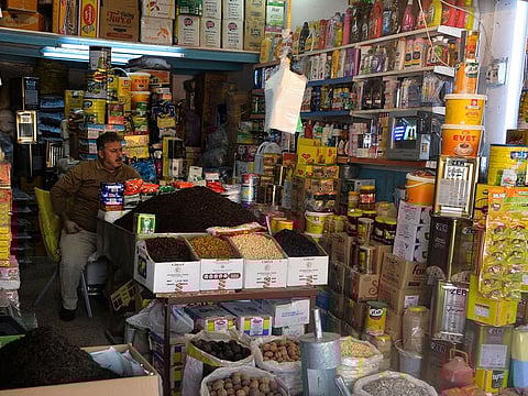 A salesman sits at a shop at the "Al-Bursa" wholesale market in the northern city of Mosul.