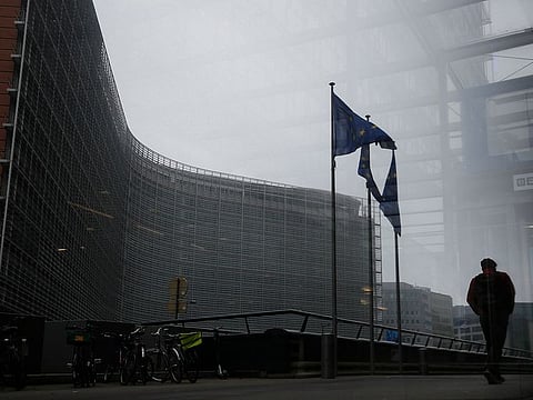 A pedestrian walks past the European Commission headquarters in Brussels, Monday Dec. 7, 2020.