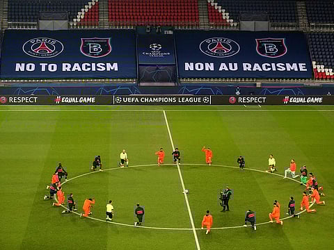 Players and officials kneel against racism before the Champions League match between Paris Saint-Germain and Istanbul Basaksehir on December 9, 2020.