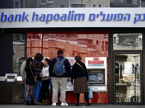 Customers wait beside automated teller machines (ATM) outside a Bank Hapoalim Ltd. bank branch in Jerusalem, Israel.