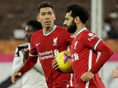Liverpool's Mohamed Salah celebrates scoring a penalty with Roberto Firmino.