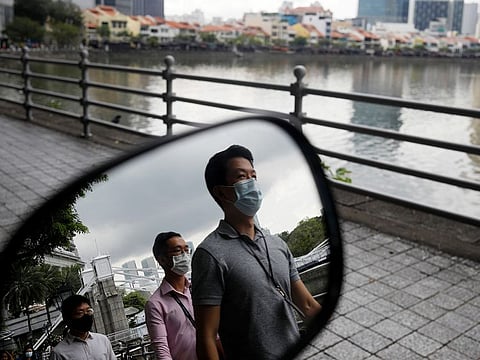 People wearing face masks as a precaution against the coronavirus disease (COVID-19) walk during lunch hour at the central business district in Singapore