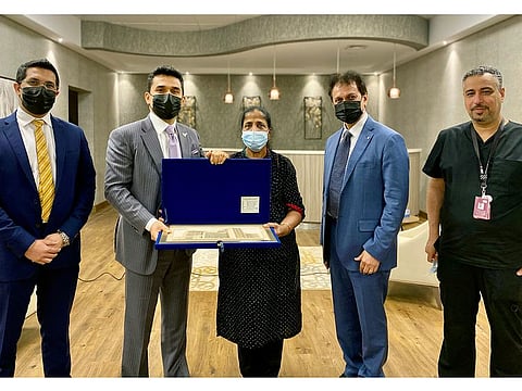 VPS Healthcare chairman and managing director Dr Shamsheer Vayalil presents a gift to Mary Mathews as a token of appreciation for her services, during her farewell function at Burjeel Hospital, Abu Dhabi.