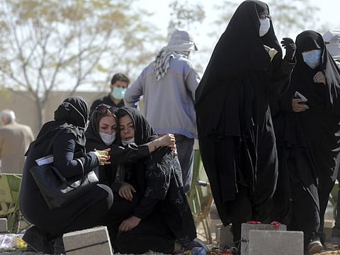 Mourners attend the funeral of a person who died from COVID-19 at the Behesht-e-Zahra cemetery just outside Tehran.