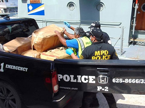 Marshall Islands police loading a box filled with one-kilo "bricks" of cocaine into a police pickup truck from a patrol vessel that transported the cocaine from a remote outer atoll to Majuro for confiscation and destruction.