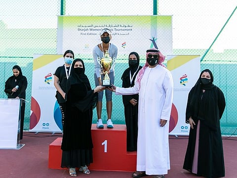 Riya Matharoo of India receives the Sharjah Women’s Tennis Championships winner's trophy from Issa Hilal Al Hazami and Nada Askar Al Naqbi