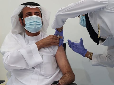 Saudi Health Minister Dr Tawfiq Al Rabiah receives the vaccine.