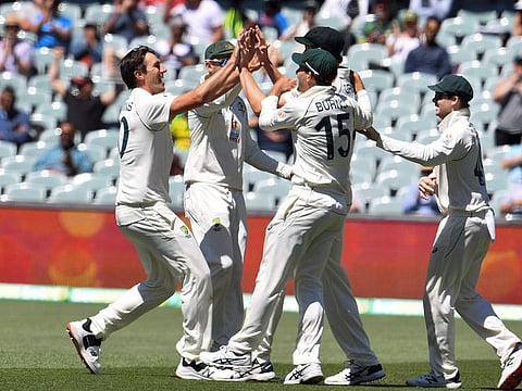SUMMER OF 36?: Australia's Pat Cummins (left) celebrates with teammates after dismissing India's captain Virat Kohli as India were all out for only 36 runs on the third day of the first Test match at Adelaide.