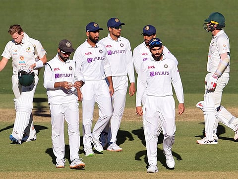 India's captain Virat Kohli (2/R) leads his players off the field after their loss to Australia on the third day of the first cricket Test match in Adelaide.