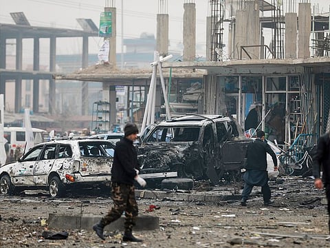 Afghan security personnel inspect the site of a bombing attack in Kabul