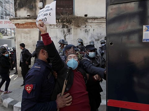 An activist affiliated with 'Human Rights and Peace Society Nepal' is detained during a protest after the parliament was dissolved and general elections were announced to be held in April and May, more than a year ahead of schedule, outside the Singha Durbar office complex that houses the Prime Minister's office and other ministries, in Kathmandu, Nepal December 21, 2020.