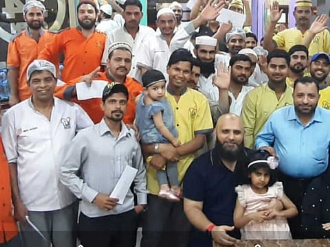 Basid Siddique (seated, second from right), a restaurant owner in Dubai, with friends and staff workers in pre-COVID-19 days. Siddique found joy in distributing food packets during the lockdown period to the needy.