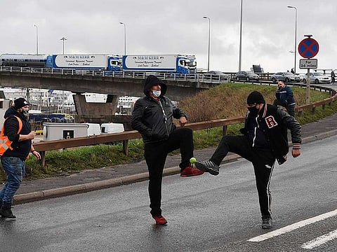 Lorry drivers play with a ball in the road leading to the entrance to the Port of Dover in Kent, south east England, on December 23, 2020, where drivers are queueing to enter after the UK and France agreed a protocol to reopen the border to accompanied freight arriving in France from the UK requiring all lorry drivers to show a negative Covid-19 test.