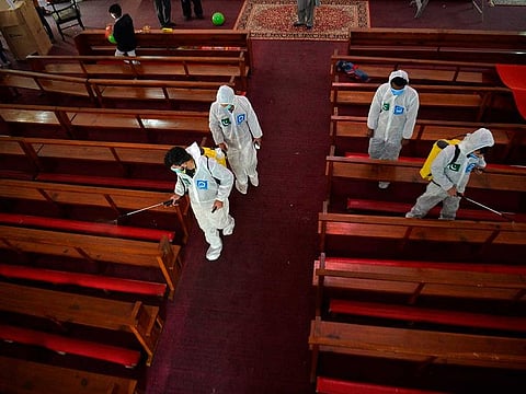 Workers of Jamaat-e-Islami Pakistan, a political party, disinfect the Fatima Church ahead of the Christmas celebrations in Islamabad on December 23, 2020.