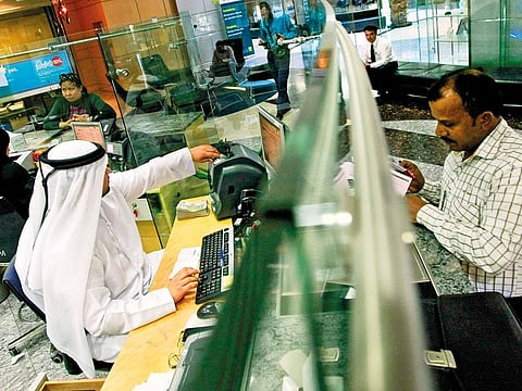 A teller at a Bank in Dubai. Bankers and analysts expect credit growth in 2020 to be largely driven by government, government related entities (GREs) and corporate sector.
