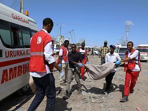 Civilians carry the dead body of a man killed in a car bomb explosion at a checkpoint in Mogadishu, Somalia December 28, 2019.