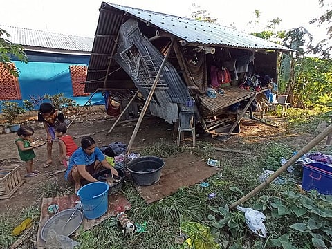 Residents stay outside their home that was damaged by Typhoon Phanfone at Concepcion town, Iloilo province, central Philippines on Friday, Dec. 27, 2019.