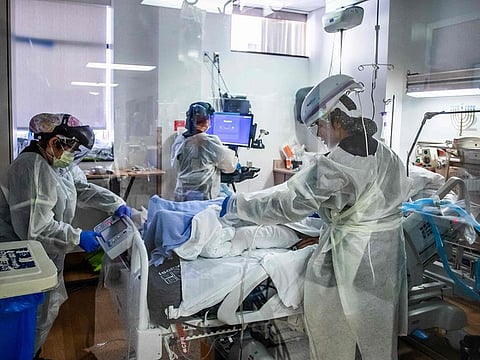Nurses wearing personal protective equipment (PPE) attend to a COVID-19 patient in the Intensive Care Unit (ICU) at Providence Cedars-Sinai Tarzana Medical Center in Tarzana, California.