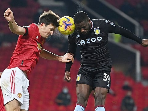 Manchester United's English defender Harry Maguire (L) vies with Aston Villa's English striker Keinan Davis (R) during the match at Old Trafford in Manchester.