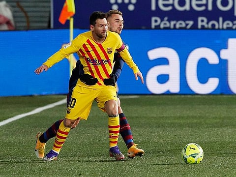 Barcelona's Lionel Messi in action with Huesca's Javi Ontiveros.