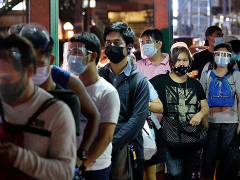 In 2020, hacking and other malware attacks surged by a whopping 2,324% from the previous year, while phishing and other social engineering schemes increased 302% from 2019, according to the Philippine central bank. File photo shows people wearing face masks and face shields as protection against the coronavirus disease (COVID-19) queue at a bus stop, in Quezon City, Metro Manila, Philippines.