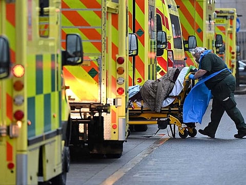 A paramedic is seen by a line of ambulances outside the Royal London Hospital in east London on January 5, 2021.