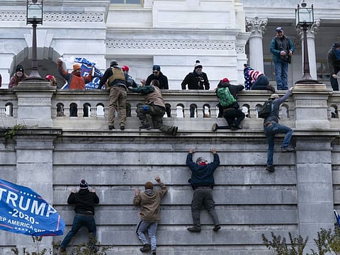 Supporters of President Donald Trump climb the West wall of the the U.S. Capitol on Wednesday, Jan. 6, 2021, in Washington