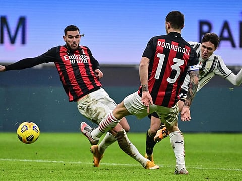 Juventus' Italian forward Federico Chiesa (hemmed in) shoots home his second goal during the Italian Serie A match against AC Milan at the San Siro stadium in Milan.