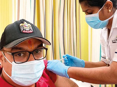 Dinesh Khiara receiving his first dose of Pfizer BioNTech vaccine at Al Mizhar Centre.