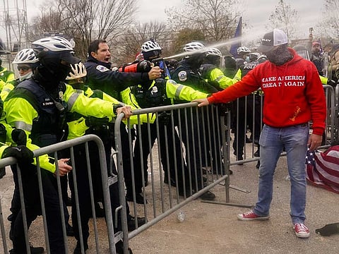 Demonstators loyal to President Donald Trump, are sprayed by police, Wednesday, Jan. 6, 2021, during a day of rioting.