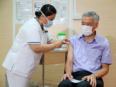 Singaporean Prime Minister Lee Hsien Loong, right, receives a vaccine for the coronavirus at Singapore General Hospital in Singapore.