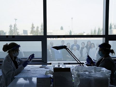 Health care workers prepare the Pfizer-BioNTech COVID-19 vaccine for medical workers at a hospital in Orange, California.