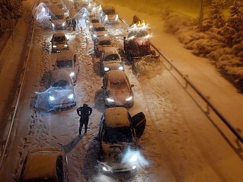 A snowplow removes snow as vehicles remain stuck in the M30 ringroad in Madrid due to a heavy snow storm.