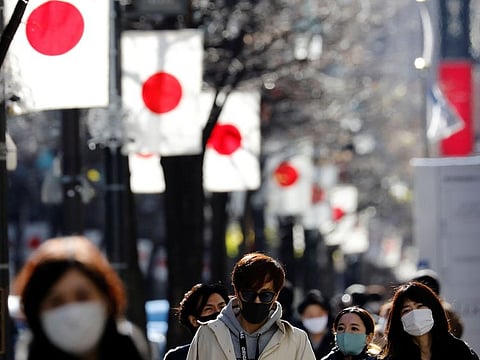 Pedestrians wearing protective masks, amid the coronavirus disease (COVID-19) outbreak, make their way at Ginza shopping district which closed to cars on Sunday in Tokyo, Japan.
