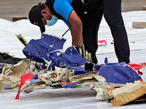 An investigator of Indonesian National Transportation Safety Committee inspects parts of Sriwijaya Air Flight 182 that crashed in the waters off Java Island, at Tanjung Priok Port in Jakarta, Indonesia.