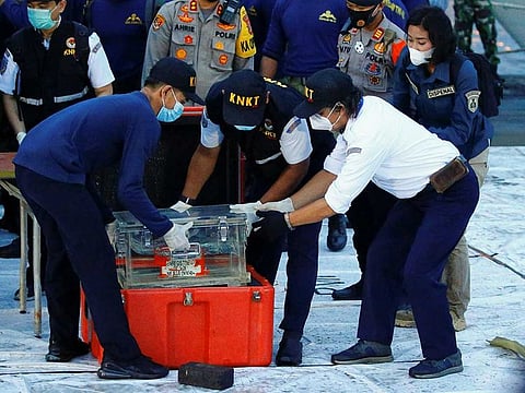 National Transportation Safety Committee (KNKT) officials hold a part of the retrieved black box of Sriwijaya Air flight SJ 182, which crashed into the sea at the weekend off the Jakarta coast, in Jakarta, Indonesia, January 12, 2021.