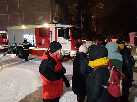People gather outside a multi-storey residential building after a fire struck an apartment in Yekaterinburg, Russia on January 12, 2021.