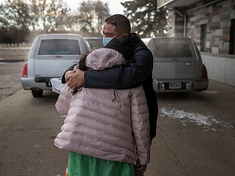 Whitney Rencountre comforts his wife Jessie Taken Alive-Rencountre at a burial for her parents, both of whom died of COVID-19, in Mobridge, South Dakota, Dec. 26, 2020.