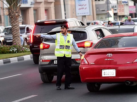 A Sharjah Police officer managing traffic.