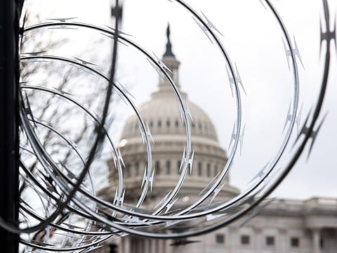Barbed wire is installed on the top of a security fence surrounding the US Capitol in Washington, DC, ahead of presidential inauguration of Joe Biden.